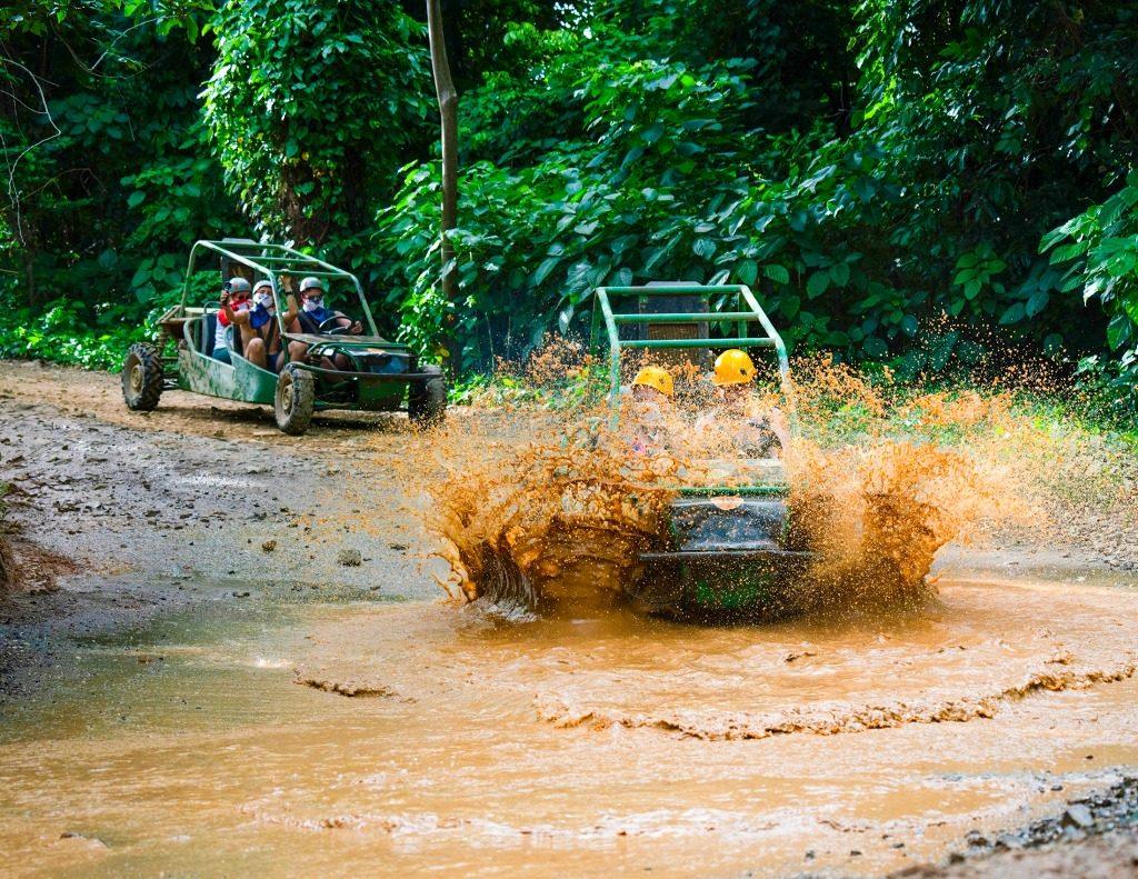 Off-road buggies driving through a muddy trail